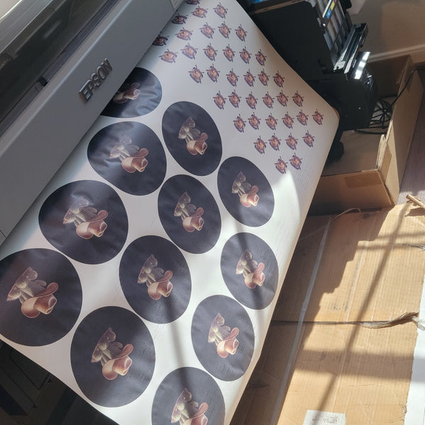 Close-up of vibrant ready to press custom sublimation transfers with a heat press, emphasizing quality and local Houston pickup service for small businesses.