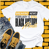 White graphic T-shirt featuring “Still Black History Month” text design, premium  printed apparel styled with denim and sneakers.