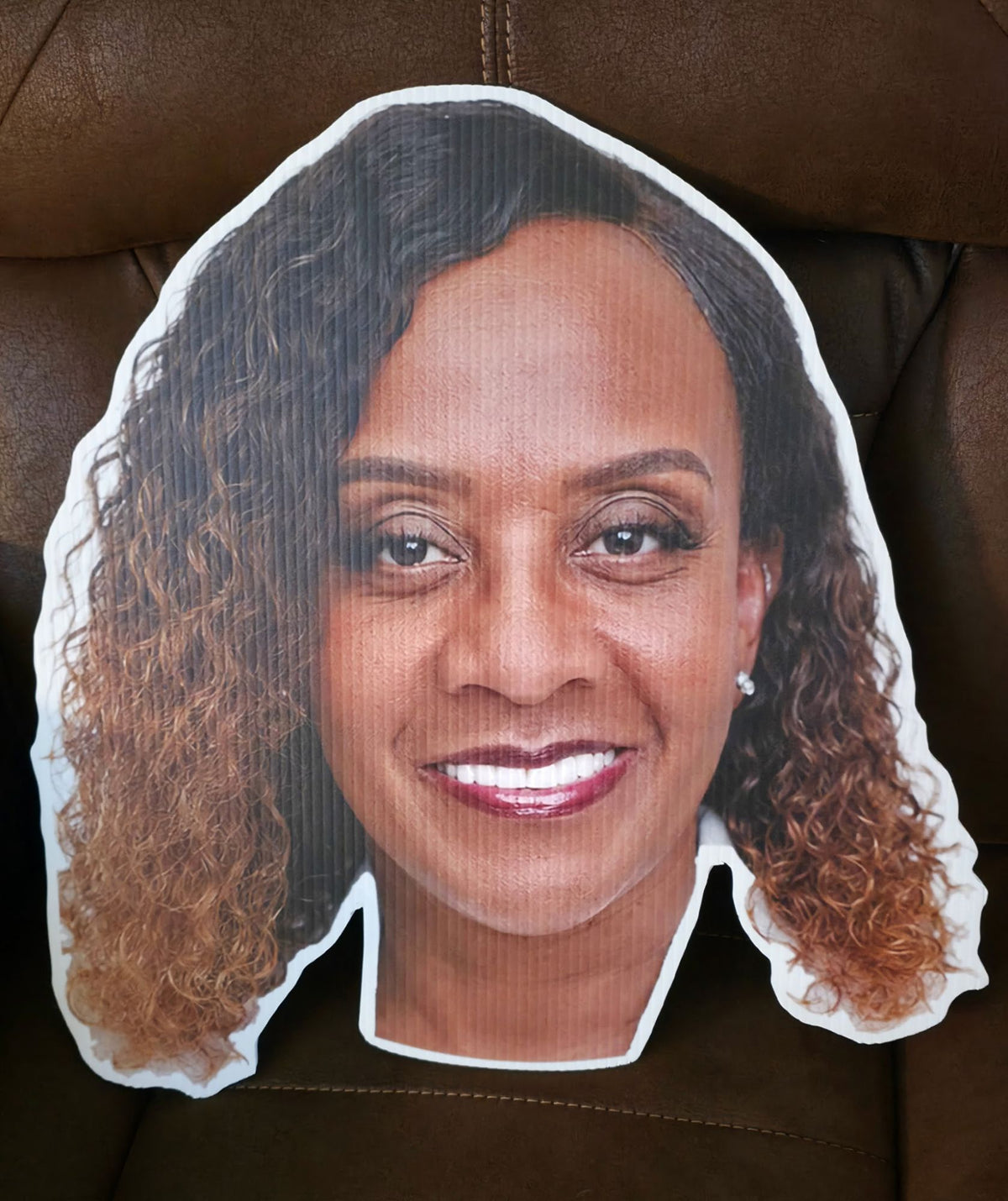 Custom big head cutout of a smiling woman's face, printed in full color on white corrugated plastic and cut to the shape of her head, standard 19 x 20 inch size