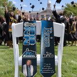 Flying Caps custom graduation stole with Class of 2026 on a chair at an outdoor commencement as graduates toss caps