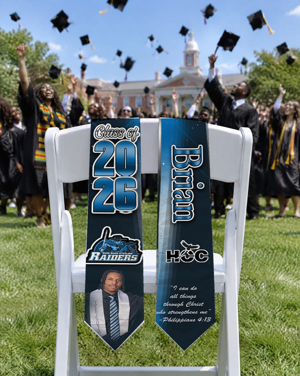 Flying Caps custom graduation stole with Class of 2026 on a chair at an outdoor commencement as graduates toss caps