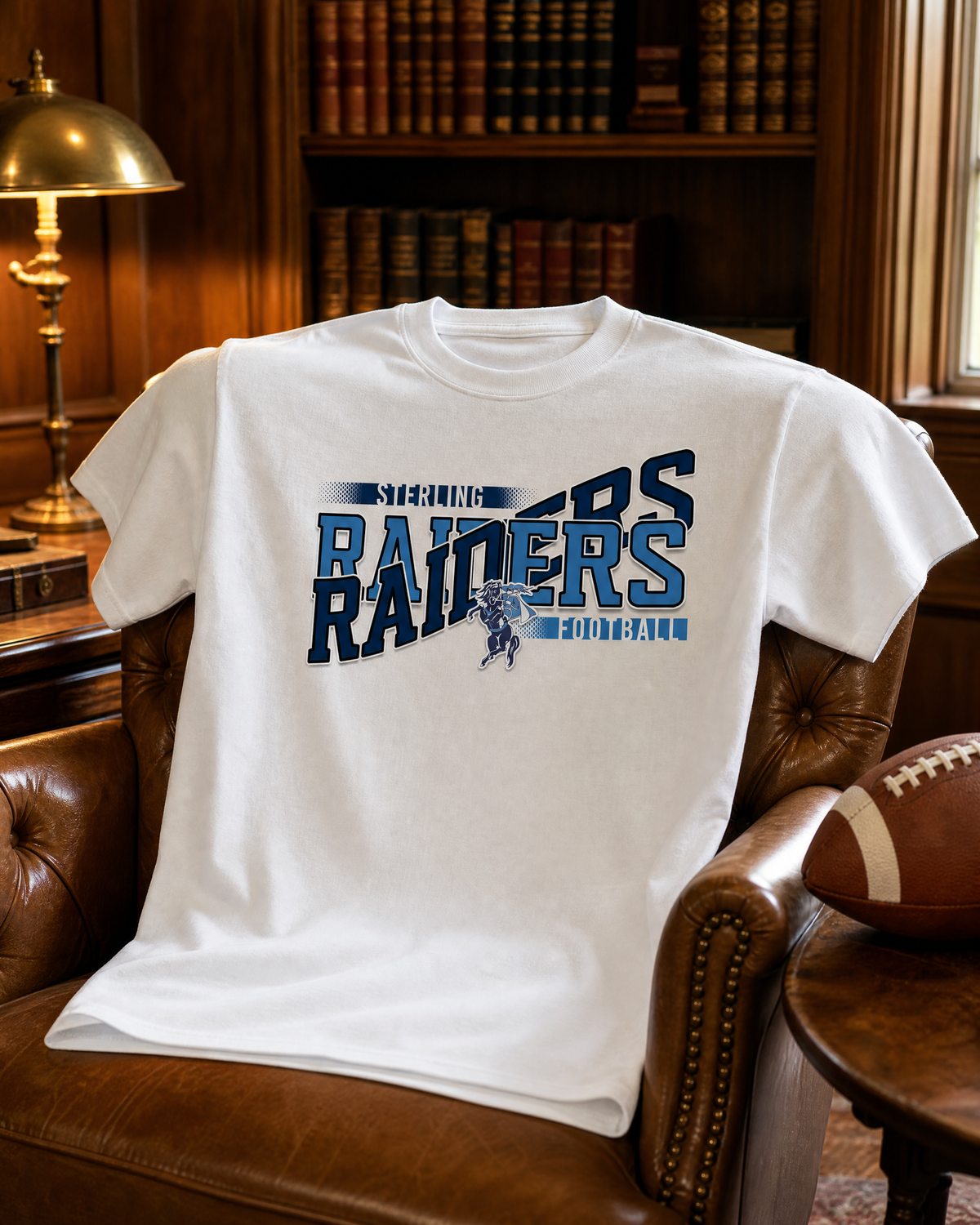 White game day spirit shirt with a navy and light blue football team design draped over a leather armchair in a home office.
