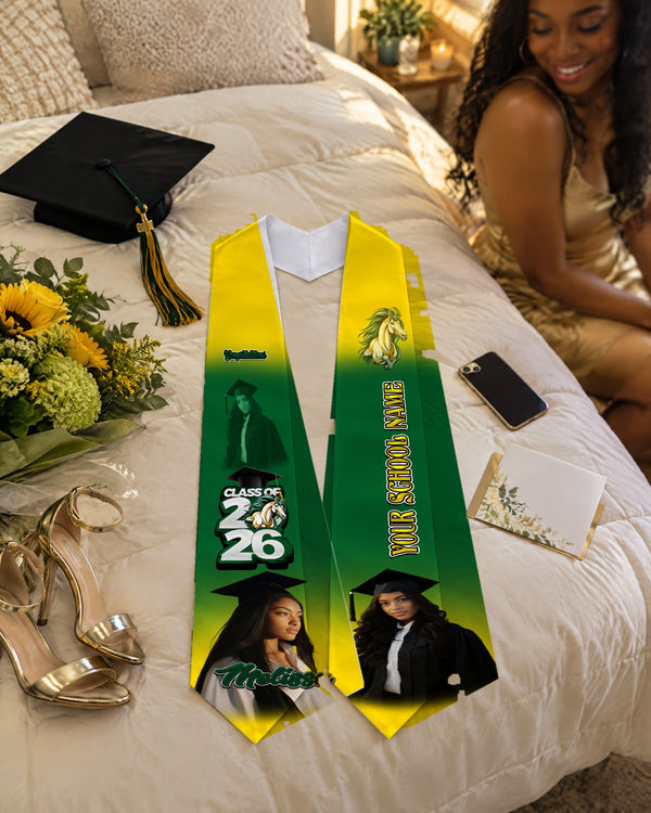 Green and gold graduation stole with Class of 2026 and horse mascot on a bed with cap, heels and flowers