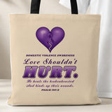Love Shouldn't Hurt tote bag, beige with black handles, purple heart and Psalm 147:3