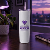 Love Shouldn't Hurt domestic violence awareness tumbler on a desk in purple evening light