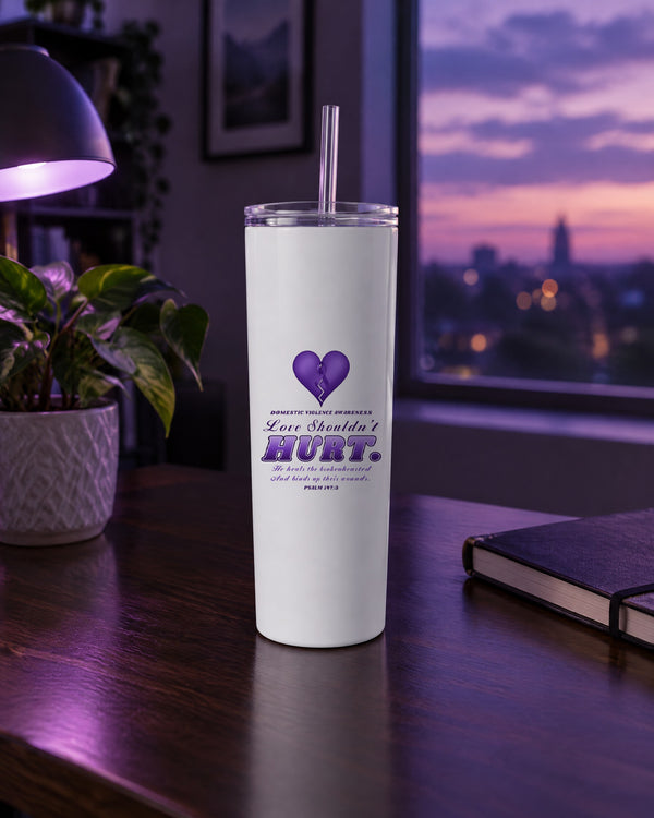 Love Shouldn't Hurt domestic violence awareness tumbler on a desk in purple evening light