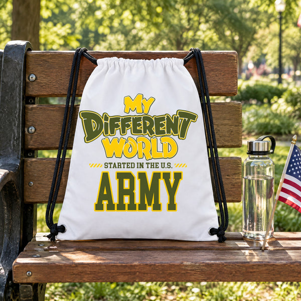 My Different World Started in the U.S. Army white drawstring backpack hanging on a wooden park bench, with a water bottle and a small American flag