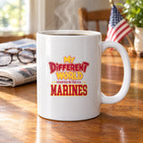 My Different World Started in the U.S. Marines coffee mug with hot coffee on a wooden kitchen table, with reading glasses, a newspaper and a small American flag