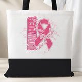 PowHerful in Pink tote bag, white with a black bottom panel and black handles, pink ribbon design