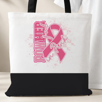 PowHerful in Pink tote bag, white with a black bottom panel and black handles, pink ribbon design