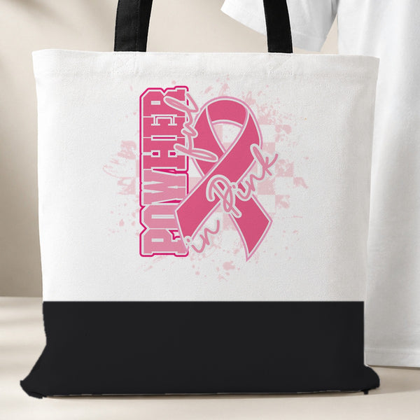 PowHerful in Pink tote bag, white with a black bottom panel and black handles, pink ribbon design