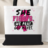 White She Fights We Pray God Moves Breast Cancer Awareness tote bag with black bottom panel and black handles