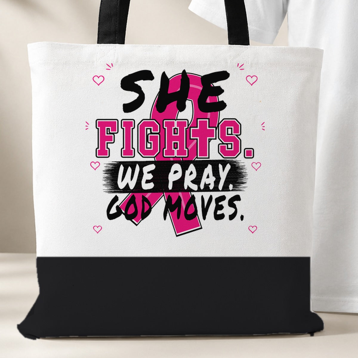 White She Fights We Pray God Moves Breast Cancer Awareness tote bag with black bottom panel and black handles