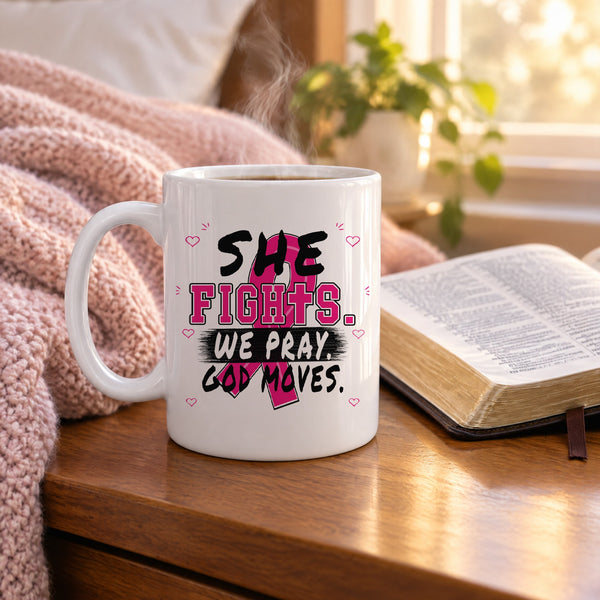 She Fights We Pray God Moves breast cancer awareness mug on a nightstand beside an open Bible
